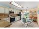 Bright kitchen with white cabinets, stainless steel appliances, skylight, and adjacent breakfast nook at 1414 Cove Pl, Tavares, FL 32778