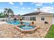 A luxurious pool area featuring a spa and beautiful stone accents, perfect for relaxing and entertaining guests at 1414 Cove Pl, Tavares, FL 32778