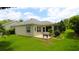 Charming backyard features a small patio, lush lawn, and mature landscaping for outdoor enjoyment at 1553 Lynchburg Loop, The Villages, FL 32162