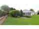 Well-maintained backyard with a screened patio, mature trees, and neatly manicured lawn at 1553 Lynchburg Loop, The Villages, FL 32162