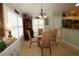 Bright breakfast nook with round glass table, four woven chairs, shuttered windows, and display cabinet at 1553 Lynchburg Loop, The Villages, FL 32162