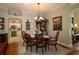 Dining room features wood table with decorative chandelier and backyard views at 1553 Lynchburg Loop, The Villages, FL 32162