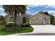 Charming home featuring a three-car garage, landscaped front yard, and elegant architectural details at 1553 Lynchburg Loop, The Villages, FL 32162