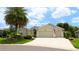 Charming single-story home with a three-car garage, complemented by a lush green lawn and mature palm tree at 1553 Lynchburg Loop, The Villages, FL 32162