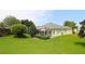 A beautiful view of the house with a screened patio and a well-maintained lawn and garden at 1553 Lynchburg Loop, The Villages, FL 32162