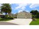 Beautiful home with a three-car garage and landscaped front yard under a sunny sky at 1553 Lynchburg Loop, The Villages, FL 32162