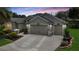 Charming home featuring a three car garage and decorative driveway, perfect for suburban living at 1553 Lynchburg Loop, The Villages, FL 32162