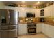 Kitchen with white cabinets, stainless steel appliances, granite countertops, and stylish decorative accents at 1553 Lynchburg Loop, The Villages, FL 32162