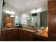 Bathroom featuring dual sinks, granite countertops, and a large mirror at 1553 Lynchburg Loop, The Villages, FL 32162