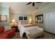 Inviting main bedroom features a comfortable seating area, plush carpeting, and a ceiling fan at 1553 Lynchburg Loop, The Villages, FL 32162