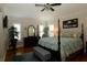 Serene main bedroom featuring a four-poster bed, hardwood floors, and plantation shutters at 1553 Lynchburg Loop, The Villages, FL 32162