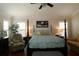 Comfortable bedroom with a four-poster bed, plantation shutters, and cozy seating area at 1553 Lynchburg Loop, The Villages, FL 32162