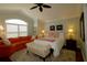 Bright main bedroom offers a seating area, ceiling fan, and lots of natural light at 1553 Lynchburg Loop, The Villages, FL 32162
