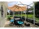 Screened in patio with outdoor table and seating, perfect for relaxing and enjoying the Florida weather at 1553 Lynchburg Loop, The Villages, FL 32162
