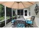 Outdoor patio with elegant seating under a large umbrella, ideal for dining or relaxation at 1553 Lynchburg Loop, The Villages, FL 32162