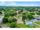 An aerial view of a well-maintained home with a lush, green lawn surrounded by mature trees in a peaceful neighborhood at 15916 Indian Wells Ct, Clermont, FL 34711