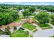 Well-maintained single-story home with a red garage door, lush lawn, mature trees, and an inviting driveway at 15916 Indian Wells Ct, Clermont, FL 34711