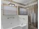 Bathroom with soaking tub, glass shower, palm tree wallpaper, and recessed lighting at 15916 Indian Wells Ct, Clermont, FL 34711