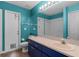 A full bathroom with white walls, a bright blue vanity, and a toilet at 15916 Indian Wells Ct, Clermont, FL 34711