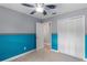 Cozy bedroom featuring stylish two-tone walls with checkerboard accent, plush carpeting, and ceiling fan at 15916 Indian Wells Ct, Clermont, FL 34711