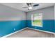 Charming bedroom featuring unique two-tone walls, plush carpeting, and a ceiling fan at 15916 Indian Wells Ct, Clermont, FL 34711