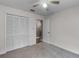 Neutral carpeted bedroom with closet, ceiling fan, and door to another room at 15916 Indian Wells Ct, Clermont, FL 34711