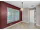 A dining room with bright natural light featuring tile floors and a decorative hanging lamp at 15916 Indian Wells Ct, Clermont, FL 34711