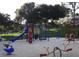 Outdoor playground featuring a slide, swings, and climbing structures in a sand-filled area at 15916 Indian Wells Ct, Clermont, FL 34711