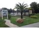 A community pool entrance with a directory sign, landscaping, and clear view of the pool at 15916 Indian Wells Ct, Clermont, FL 34711
