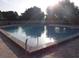 View of a community swimming pool in ground with a brick border and sun glistening on the water's surface at 15916 Indian Wells Ct, Clermont, FL 34711
