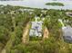 Aerial view showcasing a luxurious home near a lake, surrounded by a lush green forest, ensuring privacy and scenic beauty at 16320 Pendio Dr, Bella Collina, FL 34756