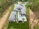 Stunning aerial view of a modern home featuring a pool, spa, and lush green turf in a private, wooded setting at 16320 Pendio Dr, Bella Collina, FL 34756