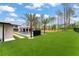An expansive backyard is enhanced by meticulous landscaping, a sleek pool, and luxurious lounging area at 16320 Pendio Dr, Bella Collina, FL 34756