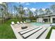 An entertainment-ready backyard patio boasts a sunken lounge and large TV, seamlessly blending luxury at 16320 Pendio Dr, Bella Collina, FL 34756