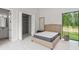 Bright bedroom features a walk-in closet, ensuite bath, and a large window with backyard views at 16320 Pendio Dr, Bella Collina, FL 34756