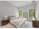 Neutral bedroom with simple decor, natural lighting and windows with backyard views at 16320 Pendio Dr, Bella Collina, FL 34756