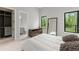 A modern bedroom showcasing a walk-in closet, ensuite bath and windows that have peaceful green views at 16320 Pendio Dr, Bella Collina, FL 34756