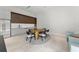 Contemporary dining area features table with seating for six, wet bar, and stainless steel refrigerator at 16320 Pendio Dr, Bella Collina, FL 34756