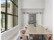 Elegant dining room with a large table, high ceilings, and abundant natural light from large windows at 16320 Pendio Dr, Bella Collina, FL 34756