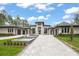 Stunning modern home featuring a beautiful paver driveway and a decorative water feature in a landscaped front yard at 16320 Pendio Dr, Bella Collina, FL 34756