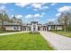 Beautiful modern home boasts professional landscaping, a decorative water feature, a paver driveway, and large front yard at 16320 Pendio Dr, Bella Collina, FL 34756