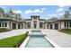 Beautiful modern home showcasing a paver driveway, a decorative water feature, and perfectly manicured landscaping at 16320 Pendio Dr, Bella Collina, FL 34756