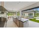 Gourmet kitchen boasts a large island with seating, top-of-the-line appliances, and backyard views at 16320 Pendio Dr, Bella Collina, FL 34756