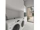 Modern laundry room features a washer and dryer, along with sink and ample storage at 16320 Pendio Dr, Bella Collina, FL 34756