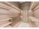 Walk-in closet with custom shelves, drawers, glass door and modern lighting at 16320 Pendio Dr, Bella Collina, FL 34756