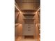 Walk-in closet features wooden custom shelves, drawers, and modern lighting at 16320 Pendio Dr, Bella Collina, FL 34756