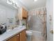 Bathroom featuring a vanity with wooden cabinets, a large mirror, and a shower with a patterned curtain at 17461 Se 82Nd Albemarle Ave, The Villages, FL 32162