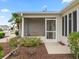 Back exterior view of home, showing a screened porch and blooming landscaping at 17461 Se 82Nd Albemarle Ave, The Villages, FL 32162