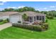 Charming single-story home featuring a well-manicured lawn, white picket fence, and a cozy screened lanai at 17461 Se 82Nd Albemarle Ave, The Villages, FL 32162