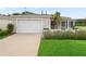 Charming single-story home with attached garage, manicured lawn, and a welcoming screened porch, freshly landscaped at 17461 Se 82Nd Albemarle Ave, The Villages, FL 32162